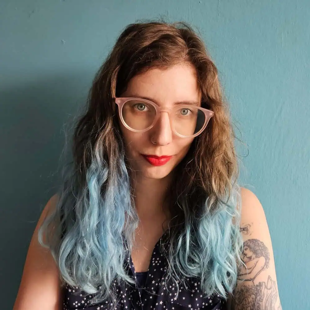 Portret autorki bloga na tle niebieskiej ściany